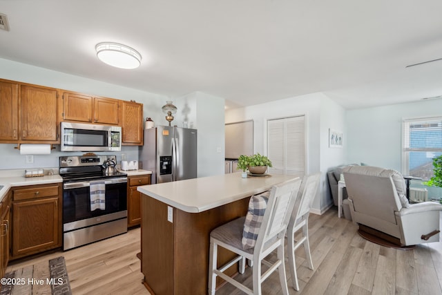 9010 W 9th St, Surf City, NC 28445 - kitchen featuring stainless steel appliances, light wood-type flooring, light countertops, and open floor plan