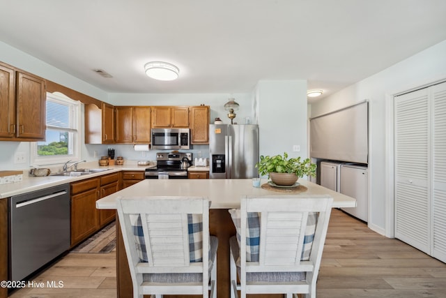 9010 W 9th St, Surf City, NC 28445 - kitchen with stainless steel appliances, washer / dryer, light countertops, and light wood-type flooring