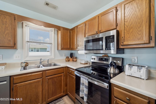 9010 W 9th St, Surf City, NC 28445 - kitchen with stainless steel appliances, brown cabinetry, and light countertops
