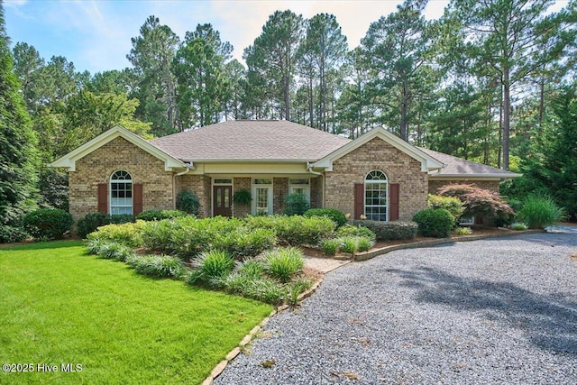 1 Pine Crest Dr, Whispering Pines, NC 28327 - ranch-style house featuring brick siding, a front lawn, and roof with shingles