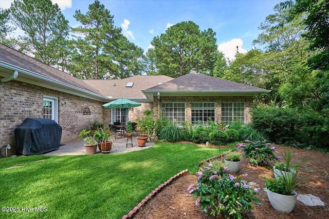 1 Pine Crest Dr, Whispering Pines, NC 28327 - back of property with a patio area, a lawn, brick siding, and a shingled roof