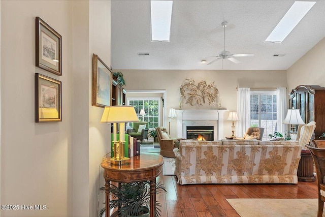 1 Pine Crest Dr, Whispering Pines, NC 28327 - living room featuring wood-type flooring, ceiling fan, a warm lit fireplace, and vaulted ceiling