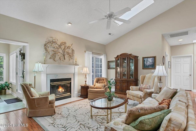 1 Pine Crest Dr, Whispering Pines, NC 28327 - living area featuring healthy amount of natural light, a fireplace, wood finished floors, a ceiling fan, and a textured ceiling