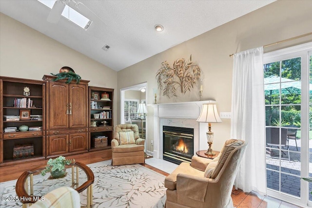 1 Pine Crest Dr, Whispering Pines, NC 28327 - living area with vaulted ceiling, a premium fireplace, a textured ceiling, and light wood-type flooring
