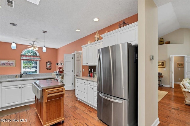 1 Pine Crest Dr, Whispering Pines, NC 28327 - kitchen with freestanding refrigerator, a kitchen island, a ceiling fan, white cabinets, and a textured ceiling