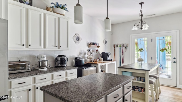 75 Bynum Ct, Vass, NC 28394 - kitchen featuring a kitchen island, backsplash, white cabinets, hanging light fixtures, and a chandelier
