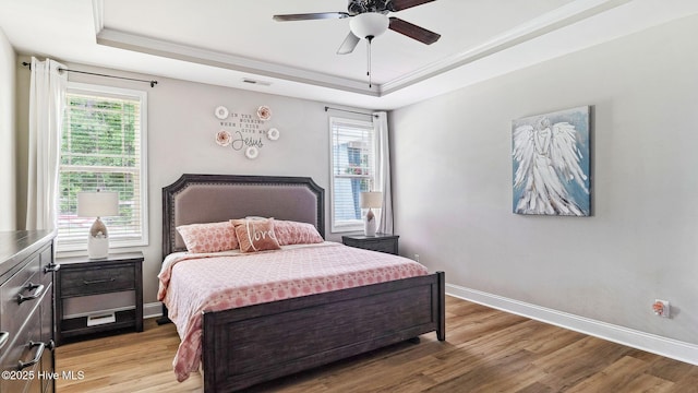 75 Bynum Ct, Vass, NC 28394 - bedroom featuring a tray ceiling, multiple windows, light wood finished floors, and ornamental molding