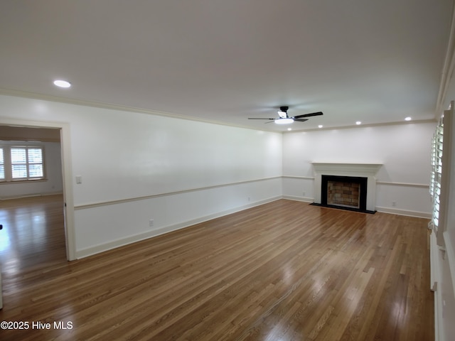 1109 Treemont Rd NW, Wilson, NC 27896 - unfurnished living room with wood finished floors, a fireplace, ceiling fan, recessed lighting, and ornamental molding