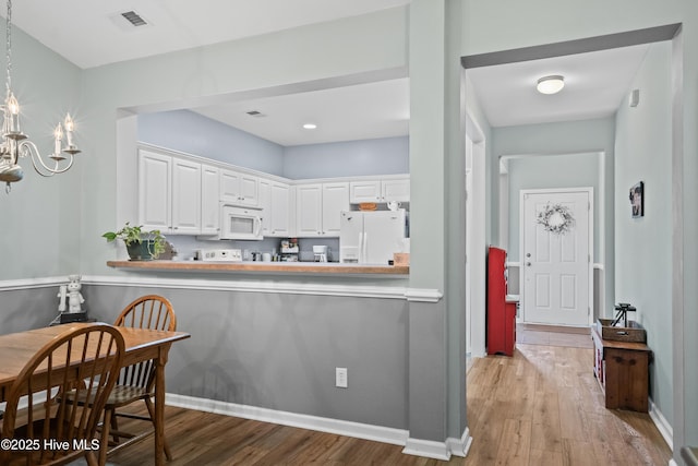 73 Field Planters Cir, Calabash, NC 28467 - kitchen with white appliances, wood finished floors, a chandelier, and white cabinets