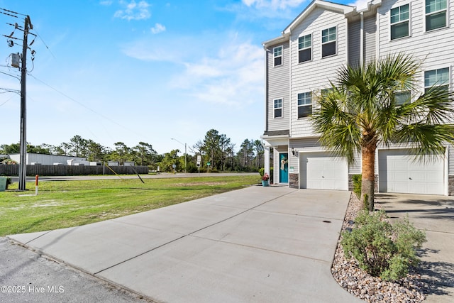 701 Elton Ave Unit 1, Carolina Beach, NC 28428 - view of front of home with concrete driveway, an attached garage, a front yard, and stone siding