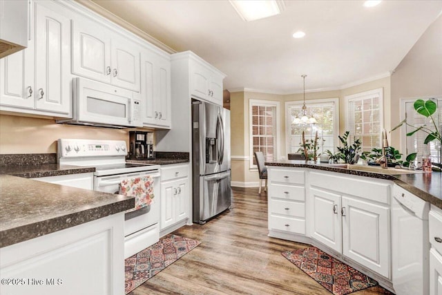 419 Morgan Trace Ln, Goldsboro, NC 27530 - kitchen with white appliances, dark countertops, white cabinetry, ornamental molding, and light wood-type flooring