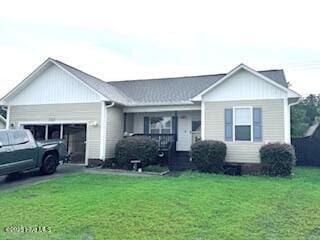 202 Oak Ridge Ln, Holly Ridge, NC 28445 - ranch-style home with a front yard, an attached garage, and covered porch