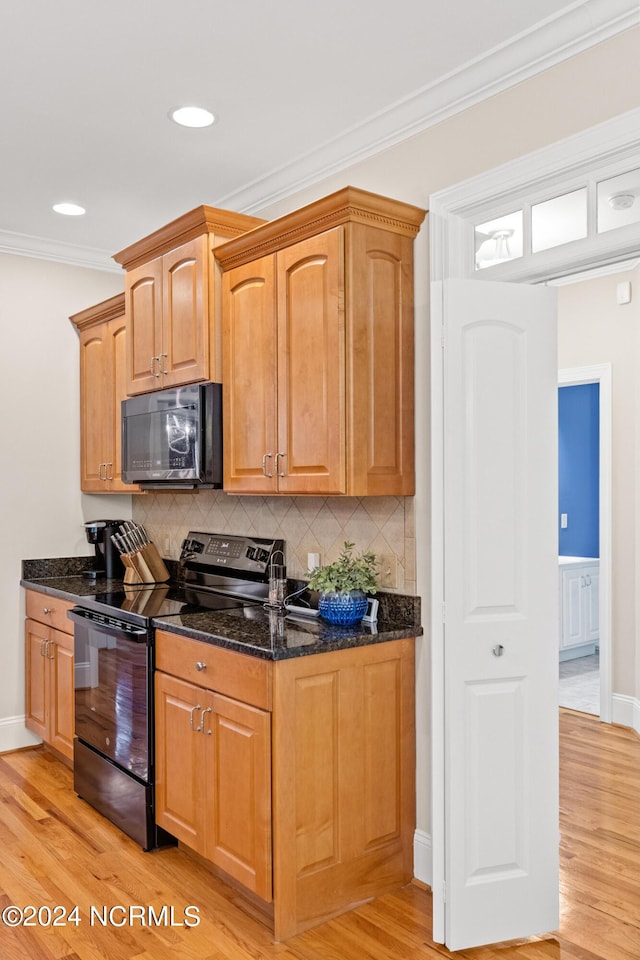 1119 Sea Bourne Way, Sunset Beach, NC 28468 - kitchen with black appliances, dark stone countertops, light wood-style floors, crown molding, and backsplash