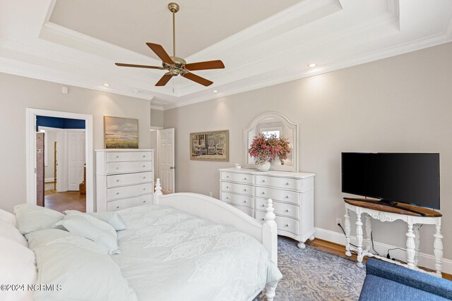 1119 Sea Bourne Way, Sunset Beach, NC 28468 - bedroom featuring a tray ceiling, ornamental molding, wood finished floors, recessed lighting, and ceiling fan