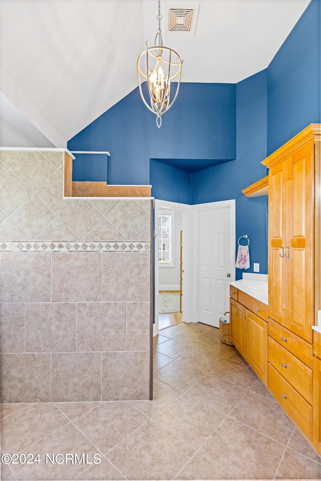 1119 Sea Bourne Way, Sunset Beach, NC 28468 - bathroom with a chandelier, high vaulted ceiling, tile patterned floors, vanity, and tiled shower
