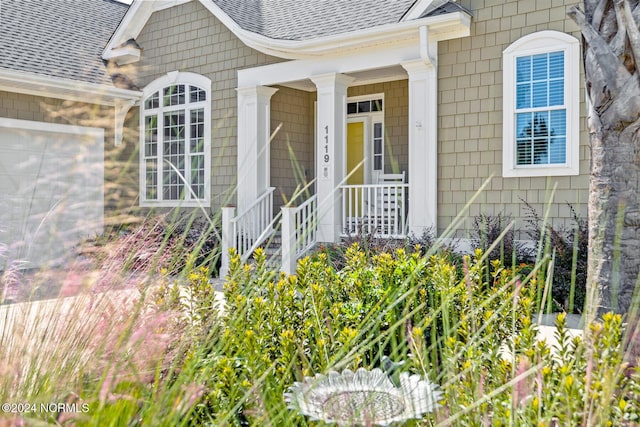 1119 Sea Bourne Way, Sunset Beach, NC 28468 - entrance to property with roof with shingles, covered porch, and a garage