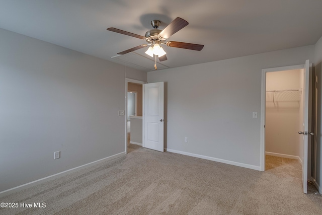 411 Isabelle St, New Bern, NC 28560 - unfurnished bedroom featuring a walk in closet, light carpet, a closet, and a ceiling fan
