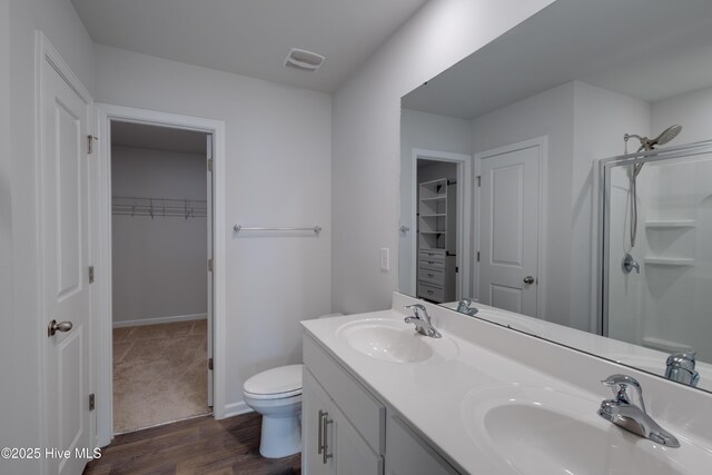 411 Isabelle St, New Bern, NC 28560 - bathroom with a walk in closet, double vanity, wood finished floors, and a shower with shower door
