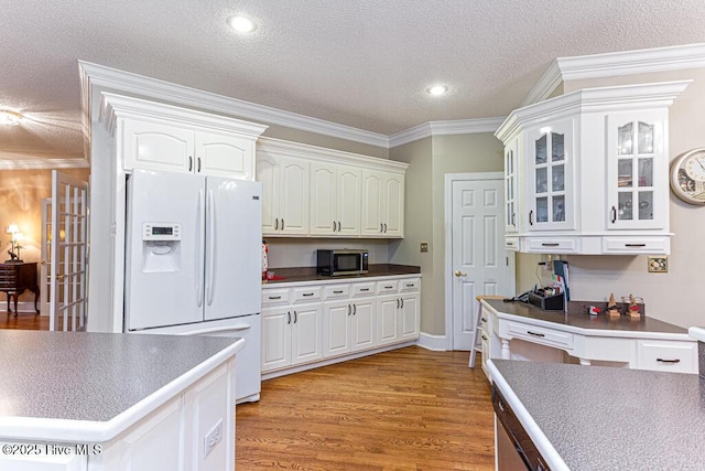 35 Magnolia Ave, Pinehurst, NC 28374 - kitchen with white refrigerator with ice dispenser, white cabinets, stainless steel microwave, glass insert cabinets, and a textured ceiling