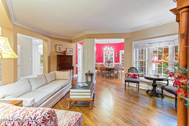 35 Magnolia Ave, Pinehurst, NC 28374 - living area featuring ornate columns, light wood finished floors, crown molding, and a chandelier