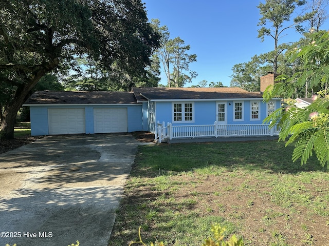 4735 Cedar Ln SW, Ocean Isle Beach, NC 28469 - ranch-style home with a chimney, concrete driveway, an attached garage, and a front lawn
