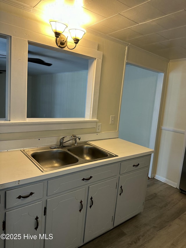 4735 Cedar Ln SW, Ocean Isle Beach, NC 28469 - kitchen featuring dark wood-type flooring, white cabinetry, light countertops, and ornamental molding