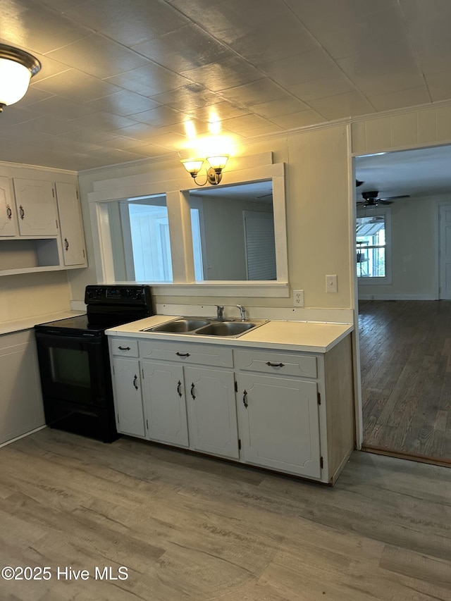 4735 Cedar Ln SW, Ocean Isle Beach, NC 28469 - kitchen with electric range, light wood-type flooring, white cabinetry, and light countertops