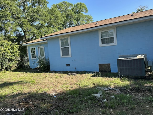 4735 Cedar Ln SW, Ocean Isle Beach, NC 28469 - view of side of property with concrete block siding, a lawn, and a shingled roof