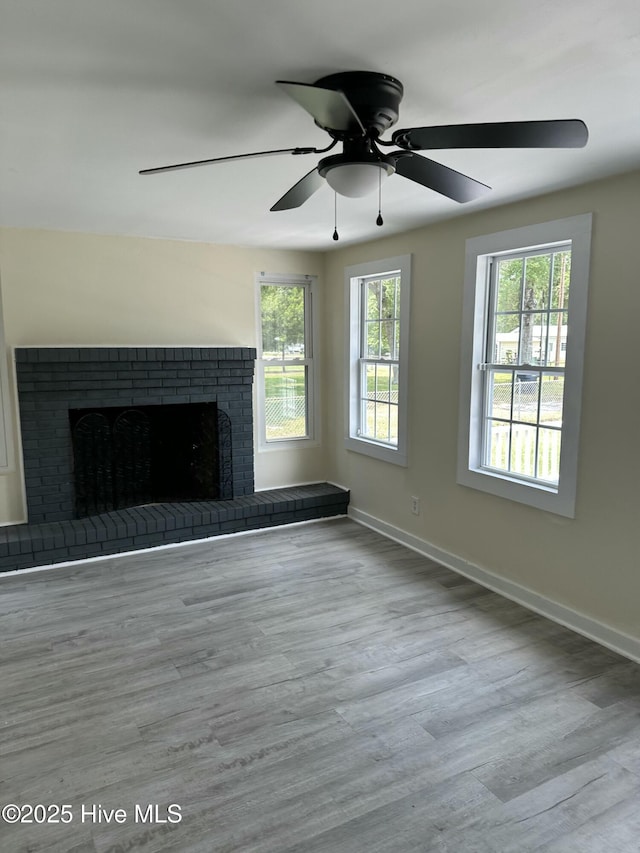 4735 Cedar Ln SW, Ocean Isle Beach, NC 28469 - unfurnished living room featuring healthy amount of natural light, a brick fireplace, a ceiling fan, and wood finished floors