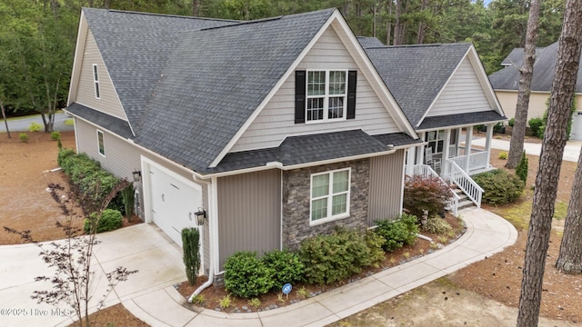 1 Miles Ct, Pinehurst, NC 28374 - view of front facade with a porch, driveway, a shingled roof, stone siding, and an attached garage
