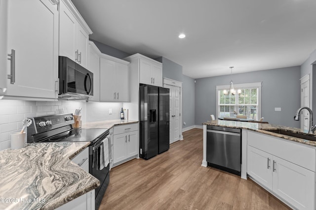 1 Miles Ct, Pinehurst, NC 28374 - kitchen with black appliances, a chandelier, light wood-style flooring, white cabinetry, and decorative backsplash