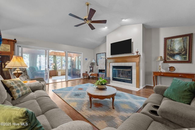 115 Baker Cir W, End, NC 27376 - living area with lofted ceiling, a ceiling fan, a tile fireplace, and wood finished floors