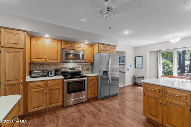 115 Baker Cir W, End, NC 27376 - kitchen featuring appliances with stainless steel finishes, light countertops, a textured ceiling, dark wood-style flooring, and backsplash