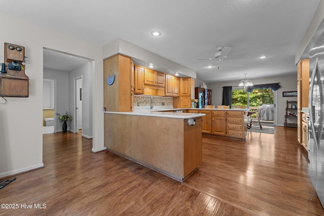 115 Baker Cir W, End, NC 27376 - kitchen featuring a peninsula, a ceiling fan, dark wood-type flooring, light countertops, and backsplash