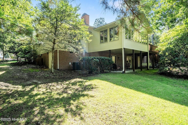 115 Baker Cir W, End, NC 27376 - rear view of house featuring a yard, a chimney, a patio, and brick siding