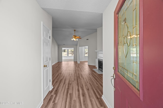 108 Bayswater Ct, New Bern, NC 28562 - foyer featuring a fireplace with flush hearth, a ceiling fan, wood finished floors, lofted ceiling, and a textured ceiling