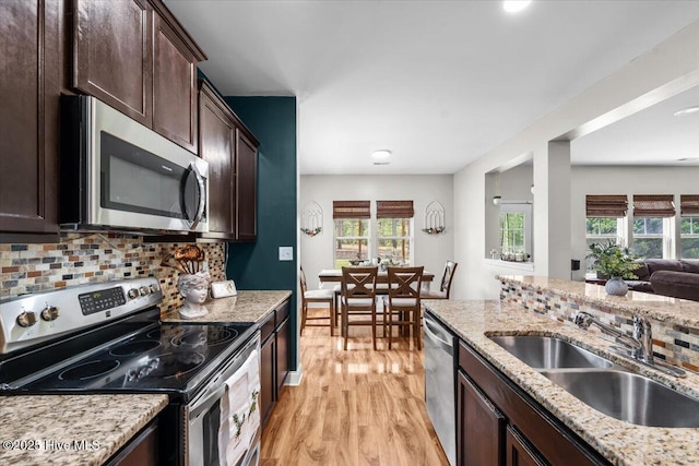 621 Longleaf Rd, Aberdeen, NC 28315 - kitchen with stainless steel appliances, light wood-style floors, dark brown cabinets, and plenty of natural light