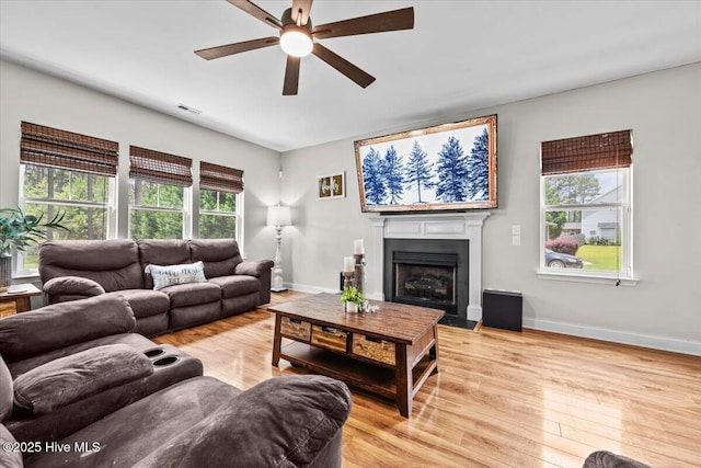 621 Longleaf Rd, Aberdeen, NC 28315 - living room featuring ceiling fan, plenty of natural light, light wood-style flooring, and a fireplace with flush hearth