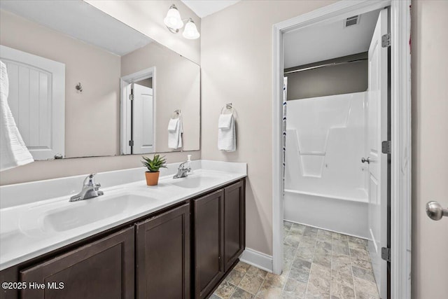 621 Longleaf Rd, Aberdeen, NC 28315 - bathroom with double vanity, stone finish floors, and shower / bath combination
