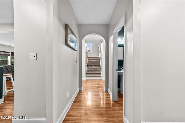 621 Longleaf Rd, Aberdeen, NC 28315 - corridor with light wood-style flooring, arched walkways, and stairs