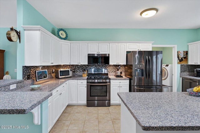 104 NE 27th St, Oak Island, NC 28465 - kitchen featuring stainless steel appliances, washer / dryer, tasteful backsplash, white cabinetry, and light tile patterned floors