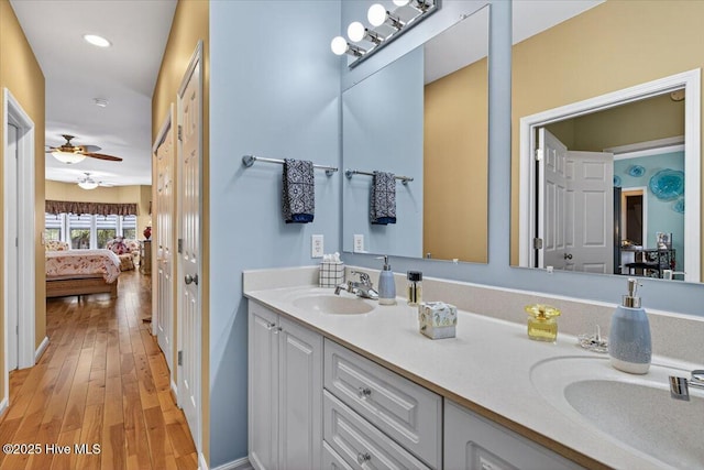 104 NE 27th St, Oak Island, NC 28465 - bathroom featuring connected bathroom, double vanity, wood finished floors, a ceiling fan, and recessed lighting