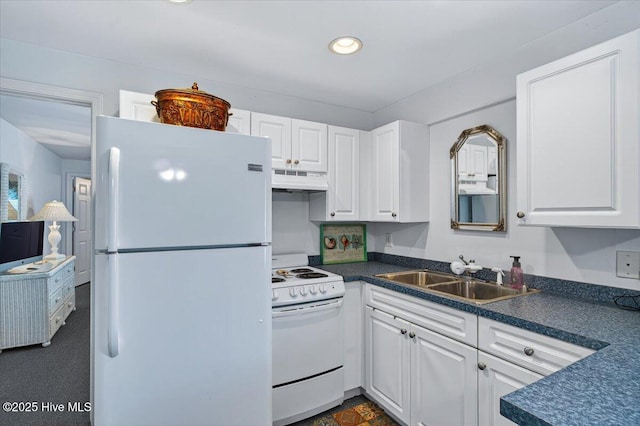 104 NE 27th St, Oak Island, NC 28465 - kitchen with white appliances, under cabinet range hood, dark countertops, white cabinetry, and recessed lighting