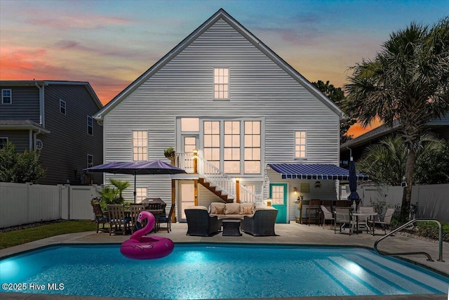 104 NE 27th St, Oak Island, NC 28465 - back of house at dusk featuring outdoor lounge area, a fenced backyard, outdoor dining area, and a patio