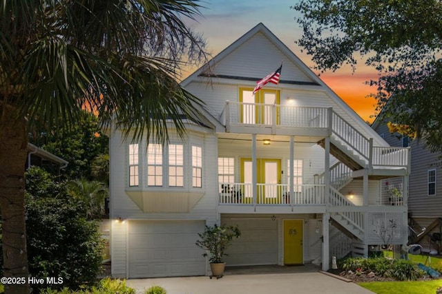 104 NE 27th St, Oak Island, NC 28465 - beach home featuring stairs, an attached garage, a balcony, and driveway