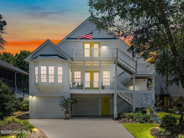 104 NE 27th St, Oak Island, NC 28465 - view of front of property with a garage, stairs, a balcony, and concrete driveway