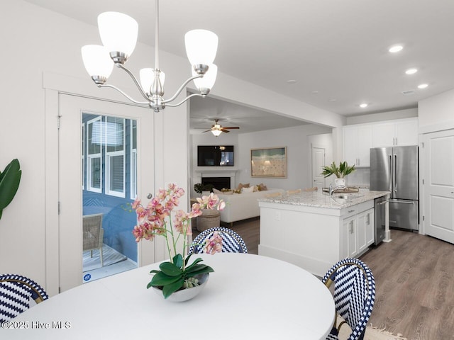 28 Legare St Lot 173, Wilmington, NC 28411 - dining room featuring a chandelier, dark wood-type flooring, recessed lighting, ceiling fan, and a fireplace