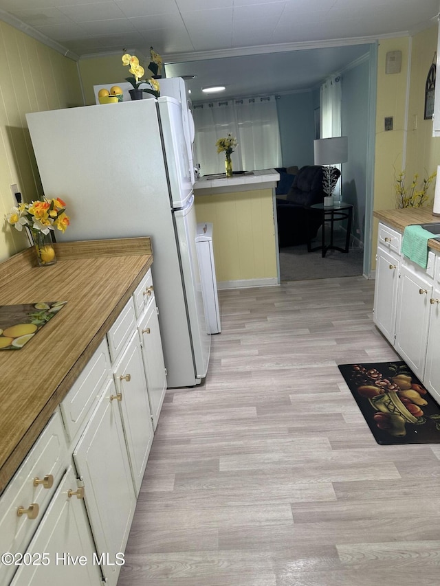 410 Brown Dr, New Bern, NC 28560 - kitchen with light wood-type flooring, white cabinets, freestanding refrigerator, ornamental molding, and wooden counters