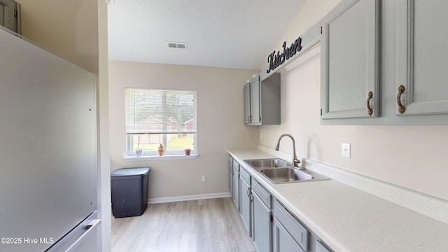 973 Ramsey Rd, Jacksonville, NC 28546 - kitchen featuring freestanding refrigerator, gray cabinets, light countertops, and light wood-style floors