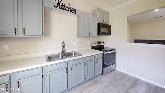 973 Ramsey Rd, Jacksonville, NC 28546 - kitchen featuring stainless steel range with electric stovetop, black microwave, light wood-style flooring, and light countertops